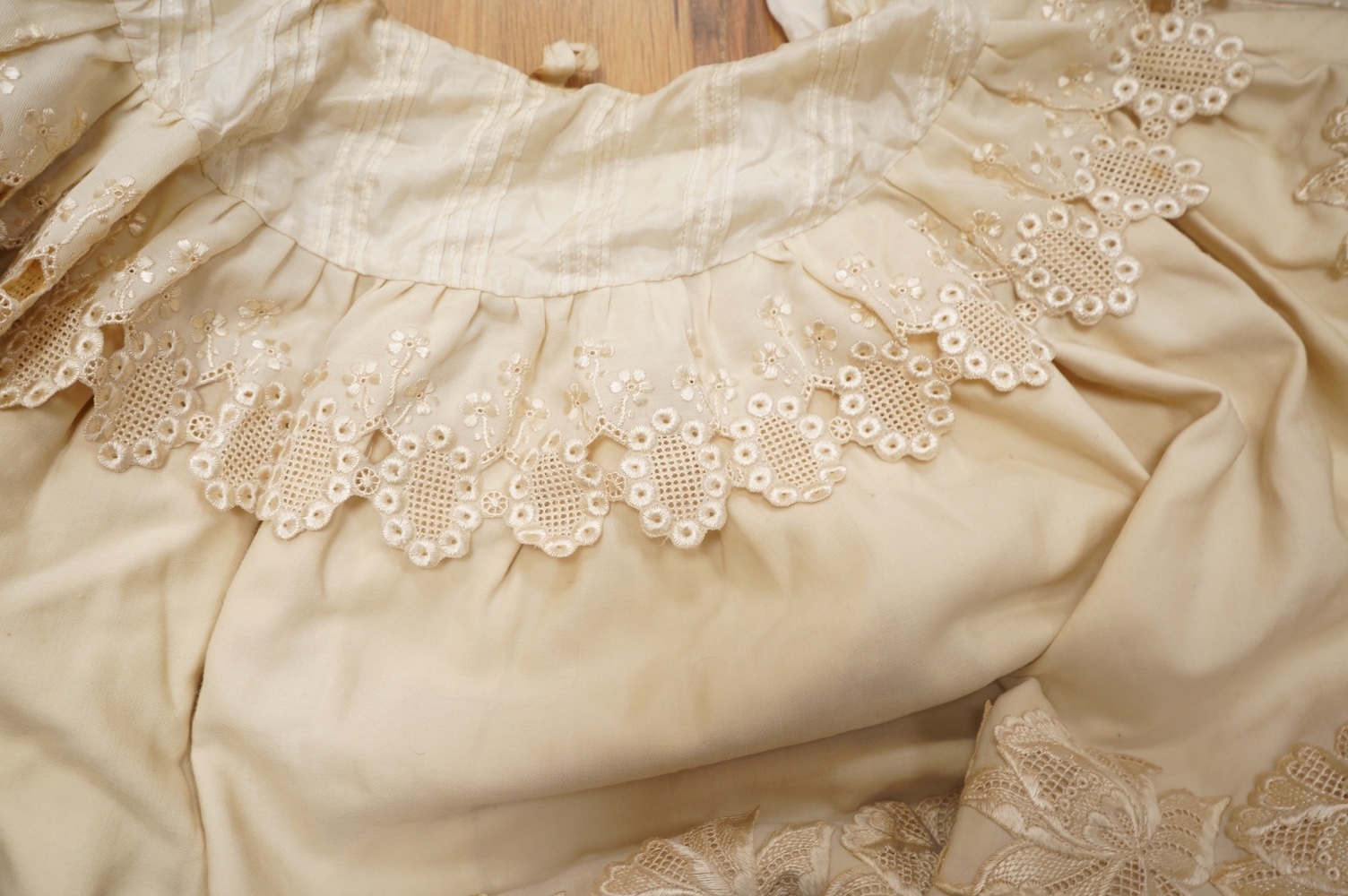A 19th century cream wool lace and embroidered christening cape and silk baby gown, cape 102cm long. Condition - some stains